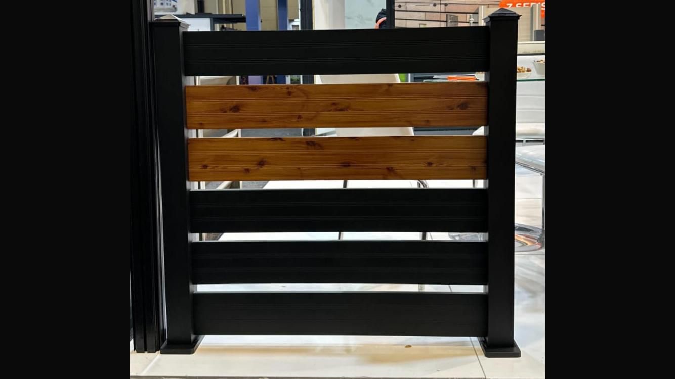 Horizontal slat fence on concrete base between two properties