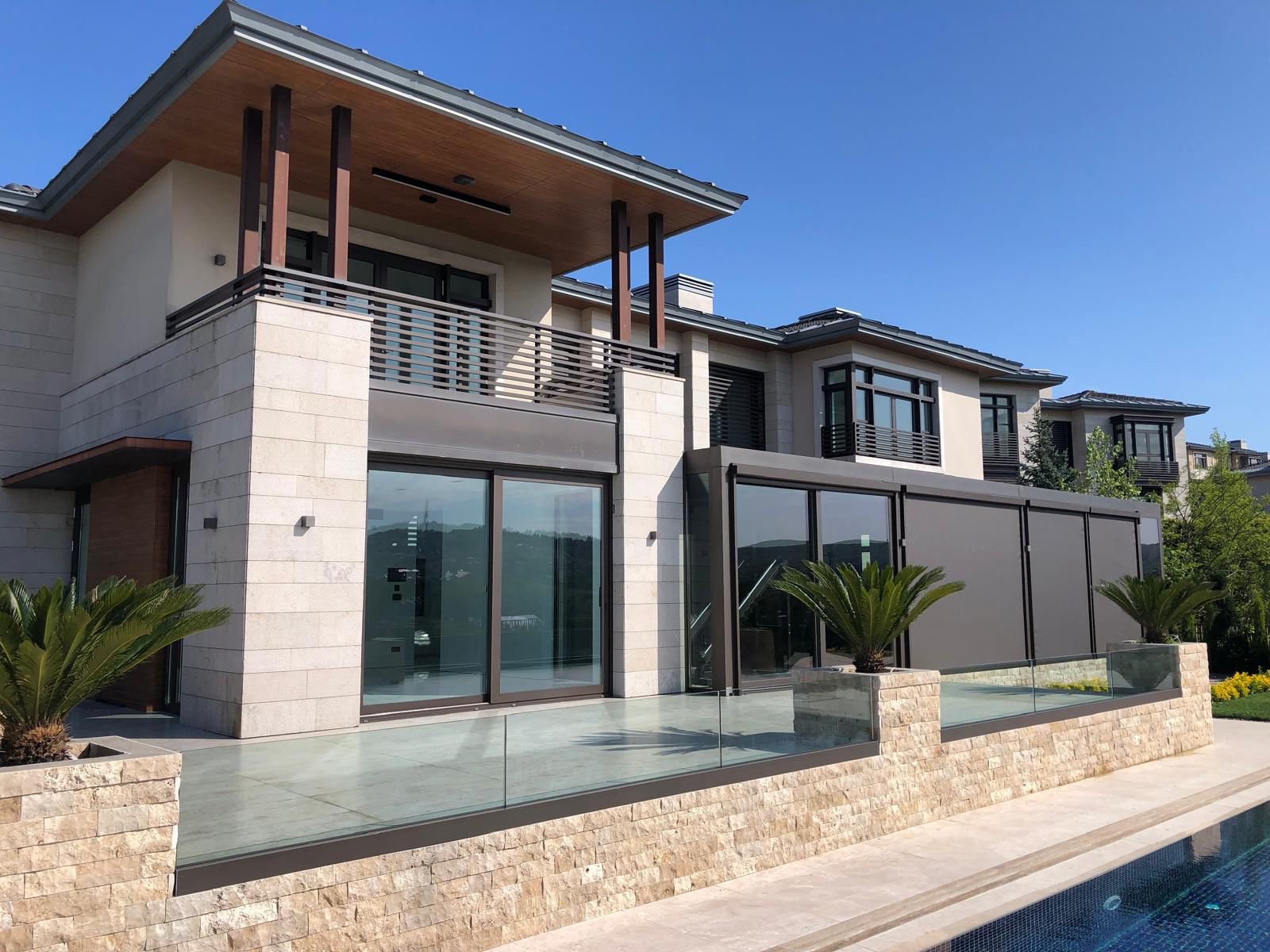 Pool and patio with glass railing and retractable shading