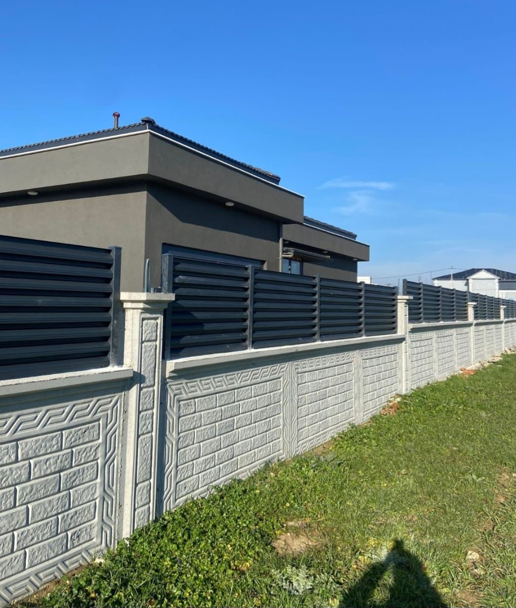 Dark gray louvered sliding gate with textured wall