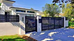 Matte black aluminum fence and gate with white pillars, modern house